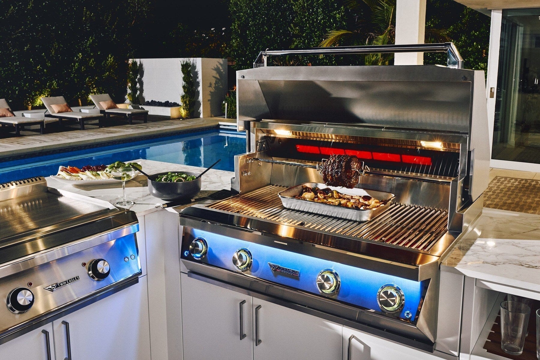 Twin Eagles built-in gas grill in stainless steel with open hood and illuminated knobs for luxury outdoor kitchens