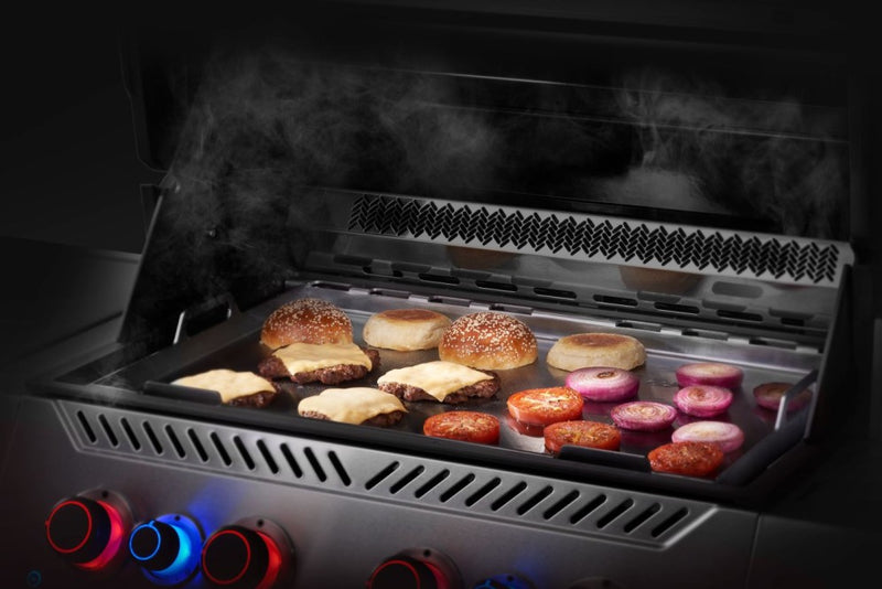 Grill with food being cooked inside, showing smoke and flames.