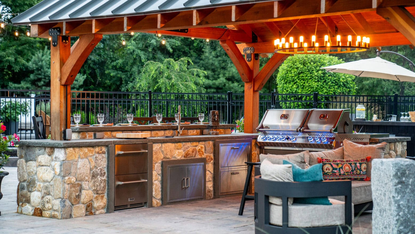 Custom outdoor living space featuring a pool with stamped concrete deck, patio seating areas, and landscaped backyard designed for entertaining.