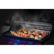 Grill with food being cooked, including shrimp and vegetables, with smoke rising.