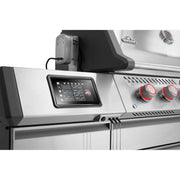 Stainless steel grill with digital control panel and red knobs on a white background