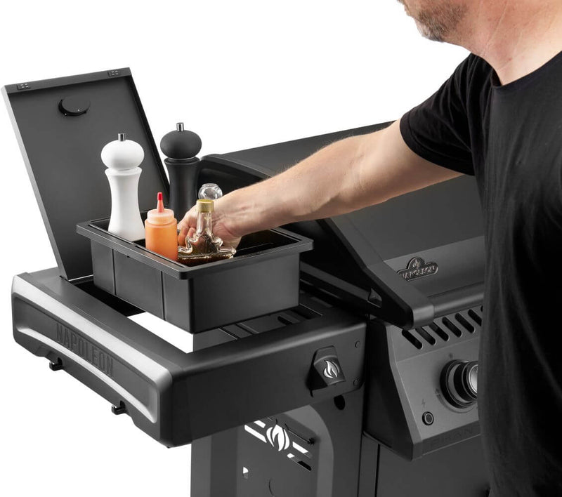Person using a portable grill with a storage compartment.