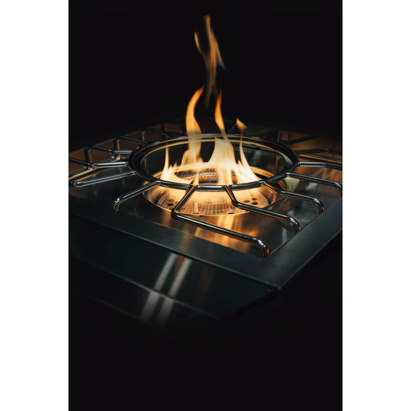 Stainless steel gas stove with flames burning on a black background